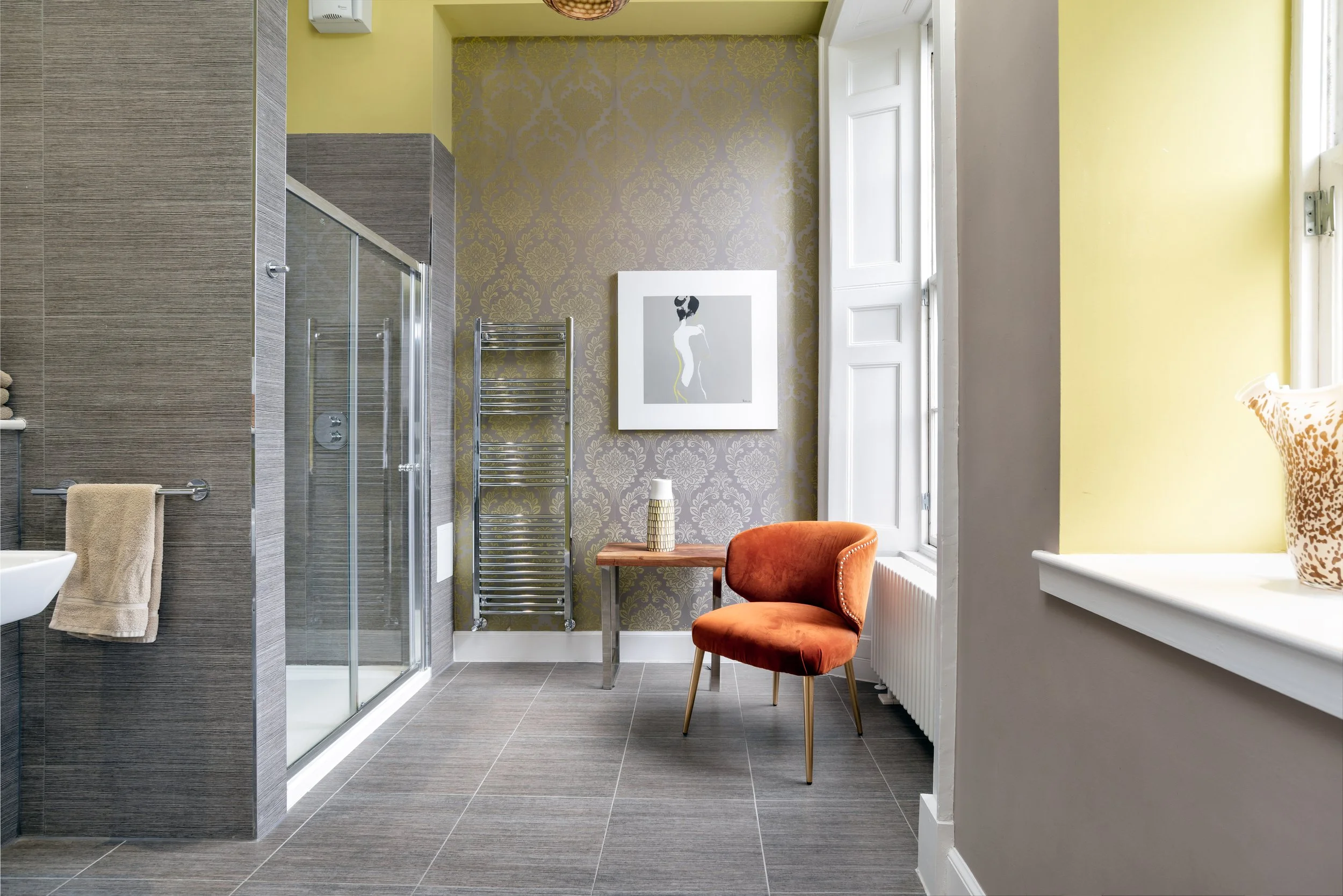 Haymarket Apartments bathroom with orange chair. aparthotel edinburgh.