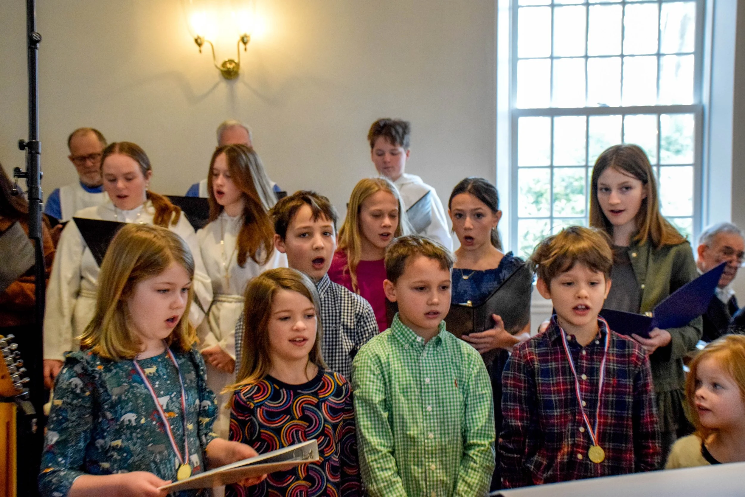 Children singing in the Saint Cecilia Youth Choir for Sunday morning worship at 10:15 AM.
