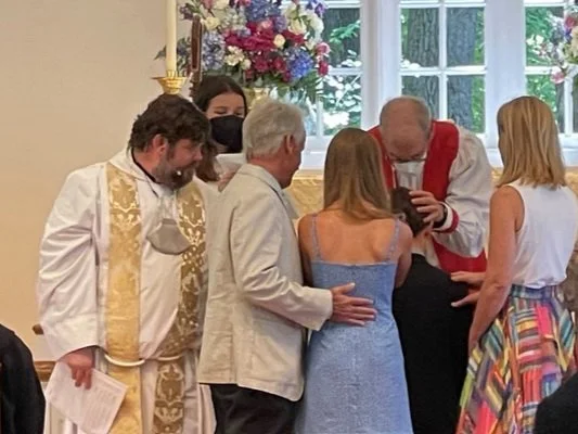 A youth member is confirmed through the Laying on of Hands by a bishop. Confirmation is typically offered once a year in late Spring