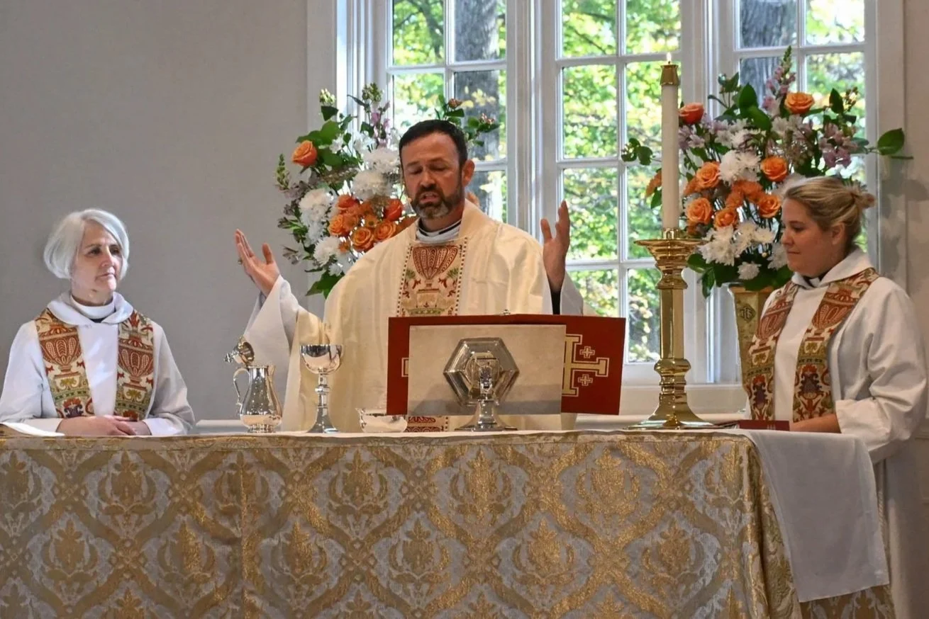 A group of men and boys singing in the Men's Choir, which practices once a month, led by a conductor.