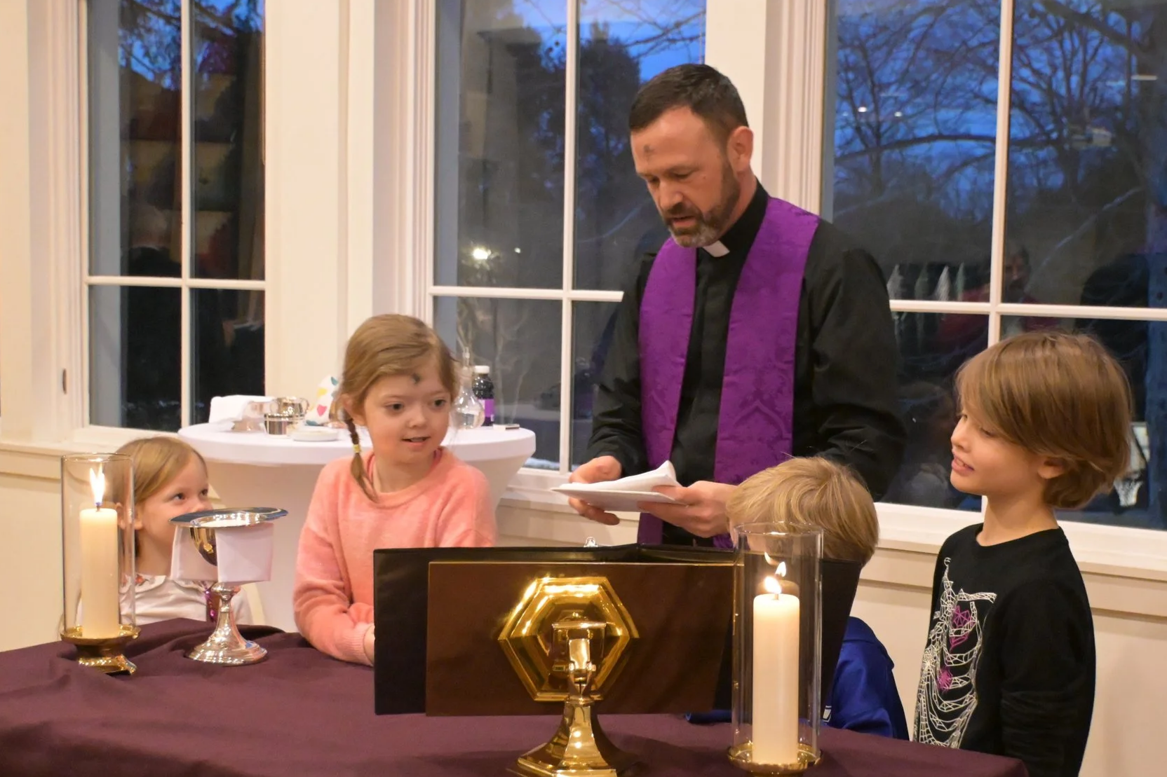 Children surrounding a table for Eucharist. 