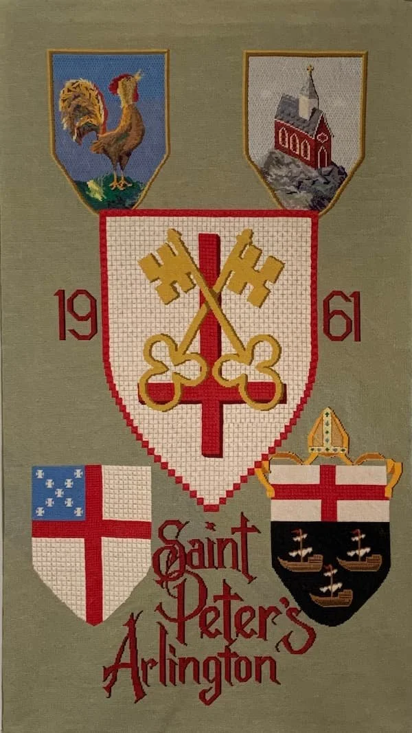 Cross-stitched embroidery of Saint Peter's Arlington with four shields and two years, 1961 and 1961.