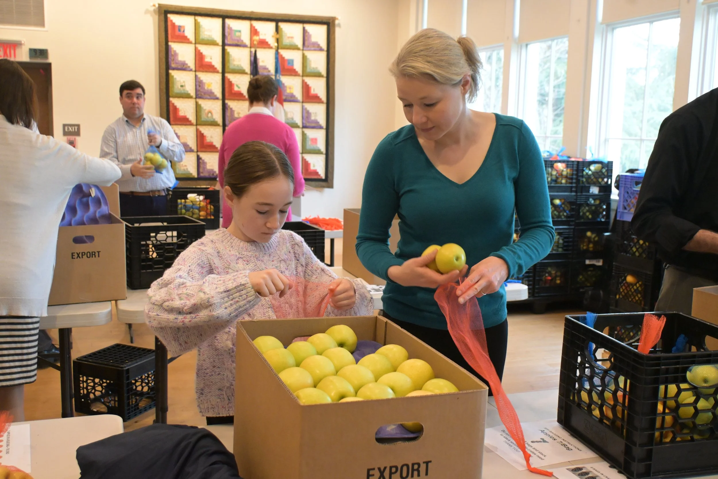 Two people bagging apples at an AFAC event at Saint Peter's Episcopal Arlington VA