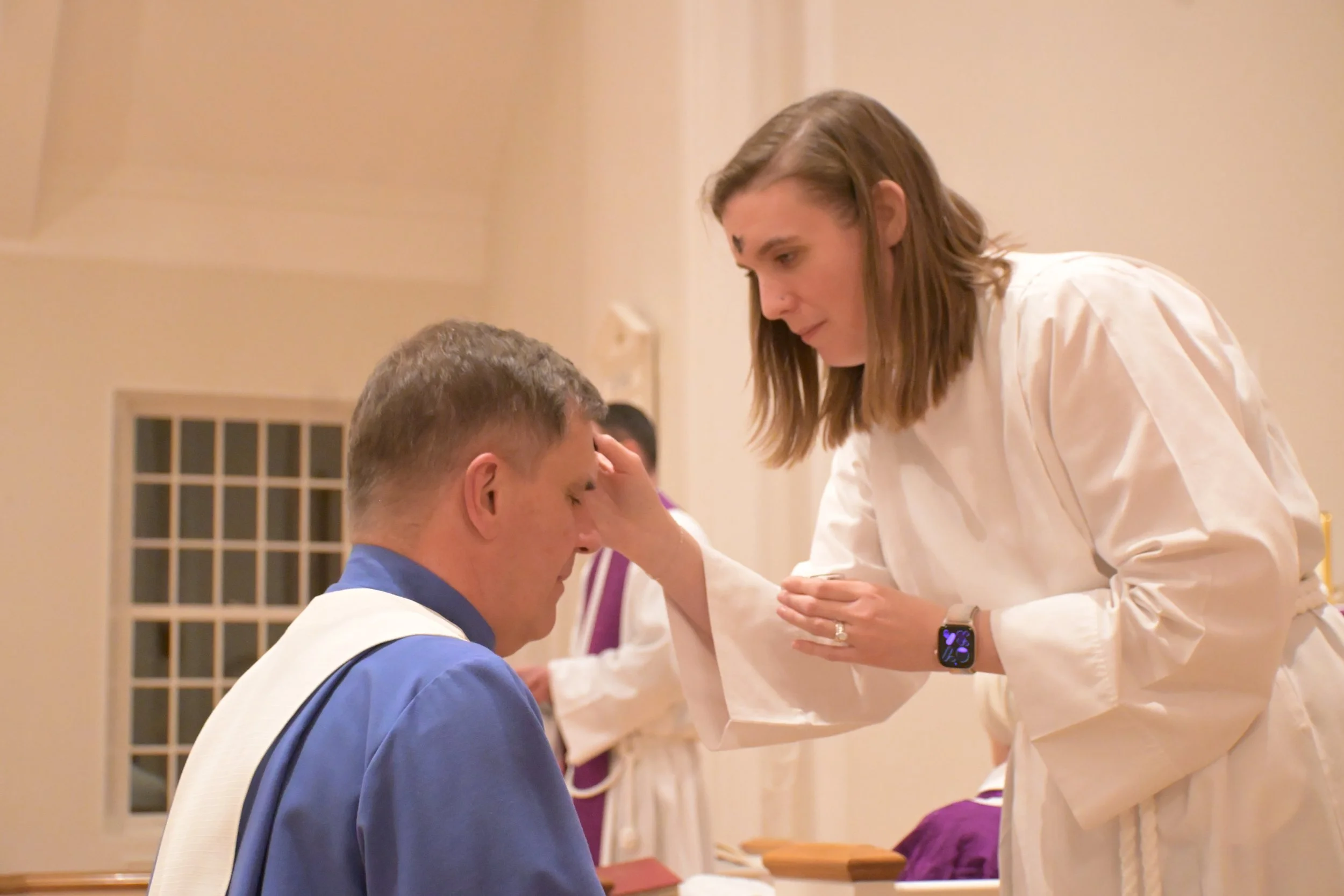 A person getting ashes imposed on their forehead.