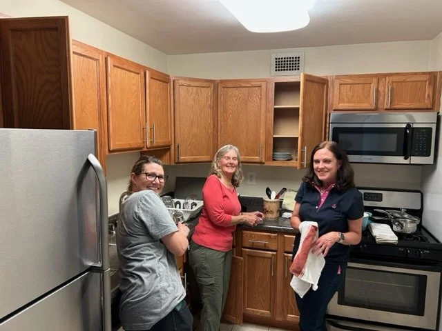 People helping to set up a kitchen