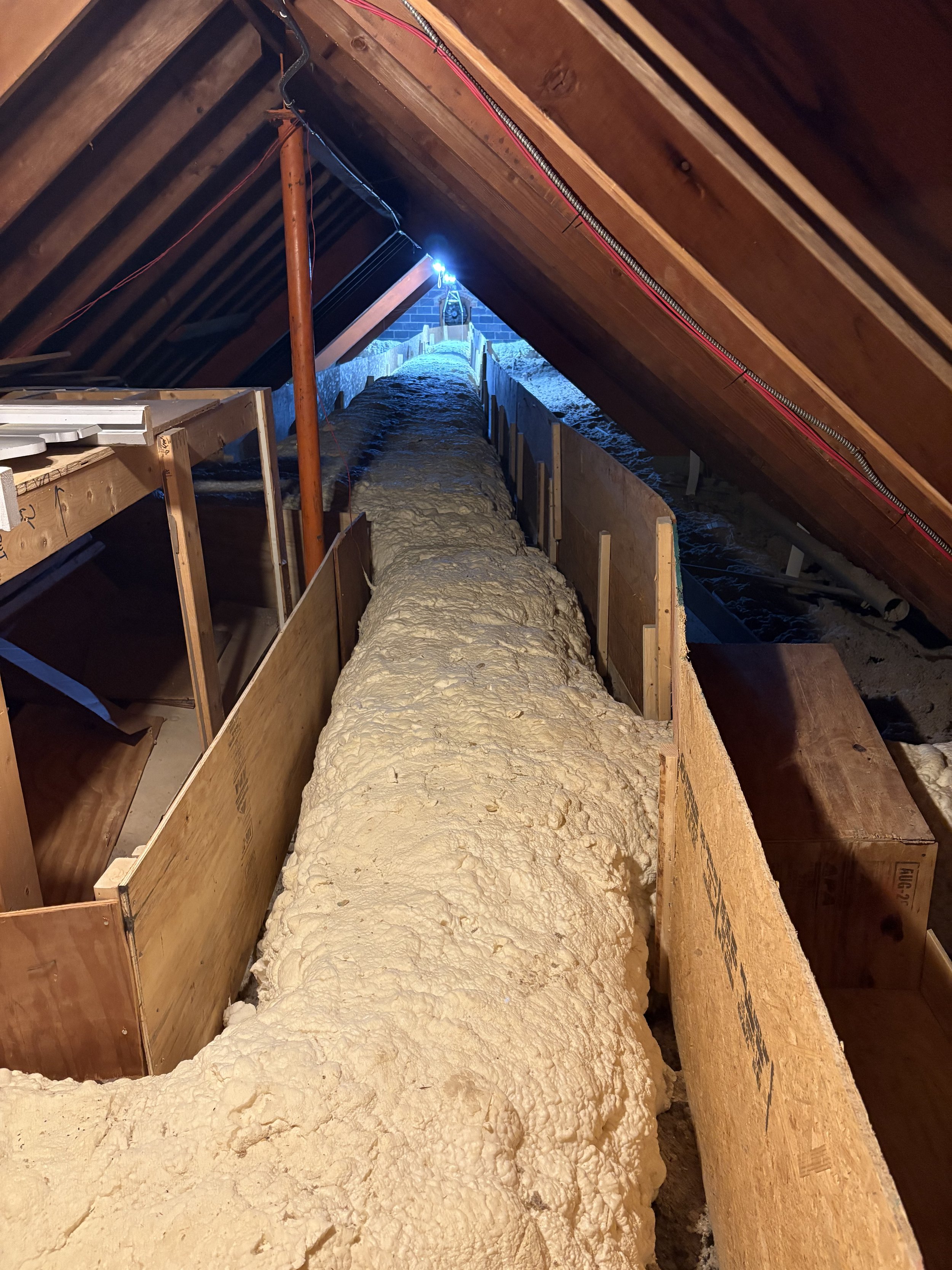 Person spraying insulation in an attic