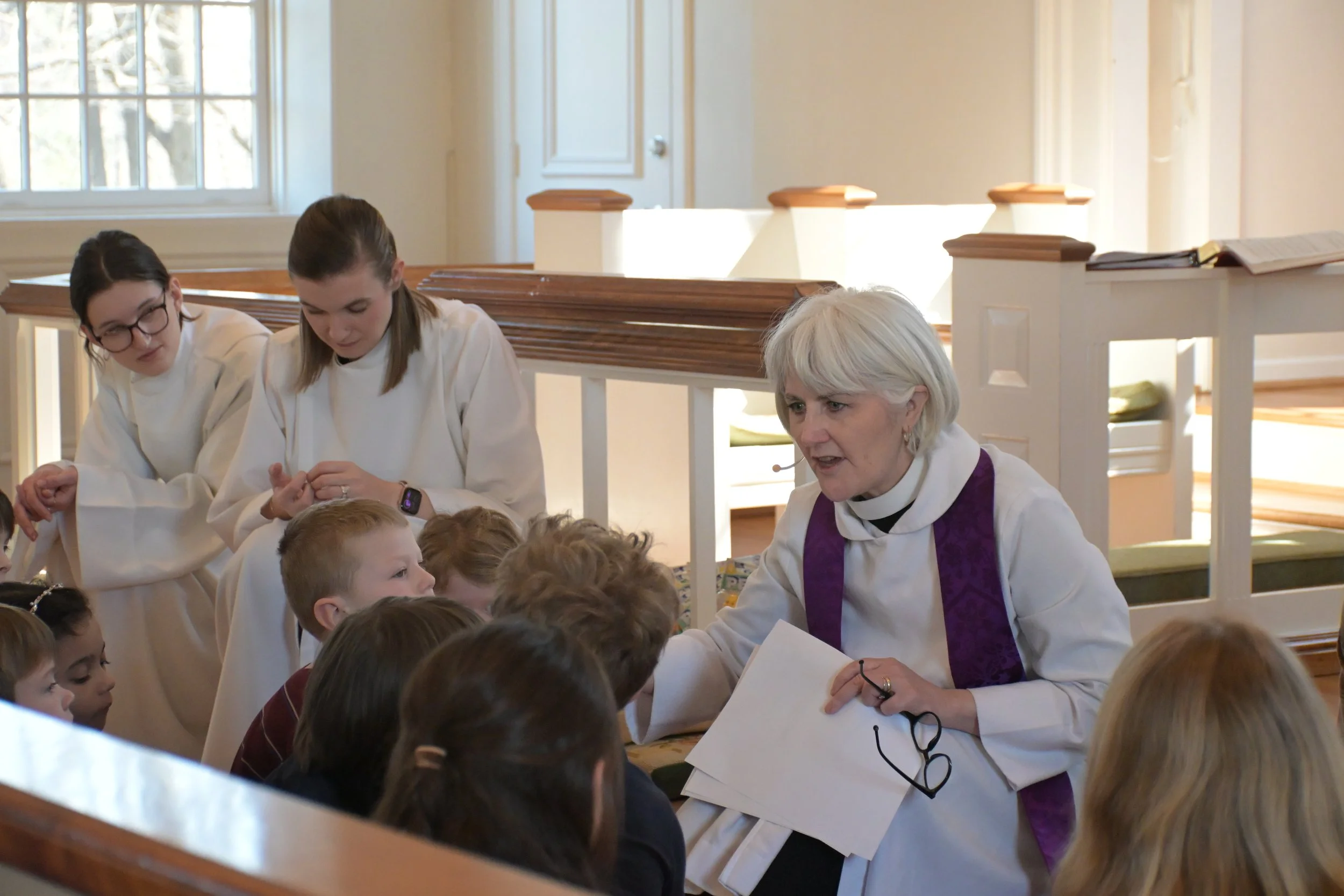 A priest giving a homily to children