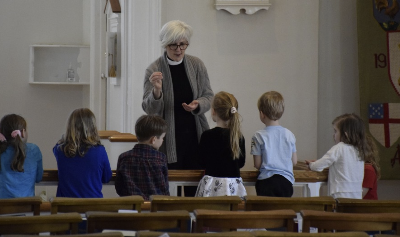 Priest offering communion to children