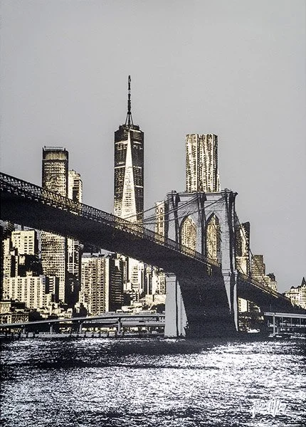 A black and white photo of the New York City skyline with the Brooklyn Bridge in the foreground and One World Trade Center in the background.