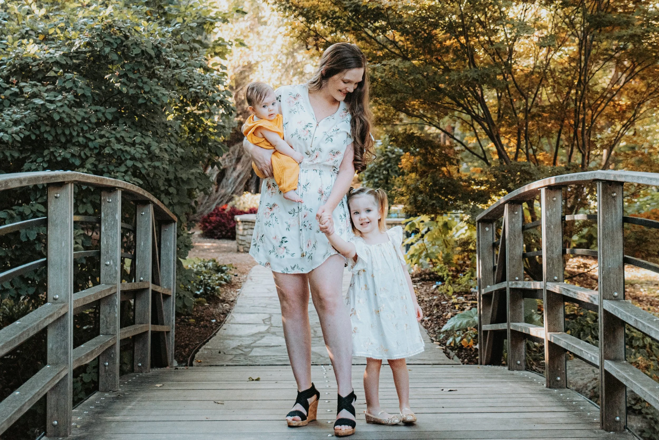 young mother and her children at the fort worth botanic gardens in fall