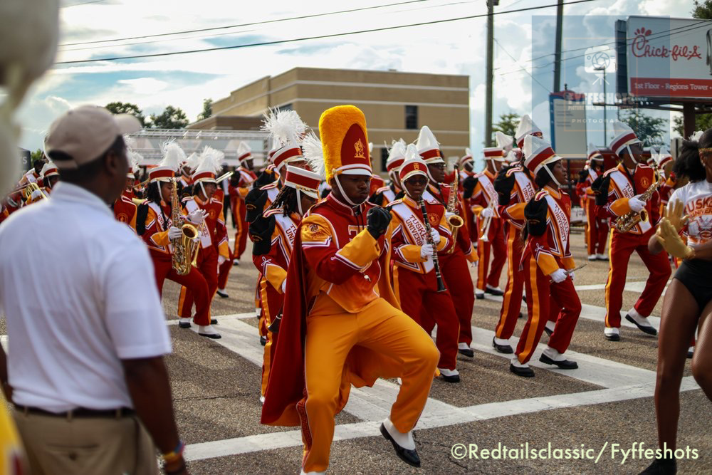 Alabama State University marching band performing in red and gold uniforms during a parade