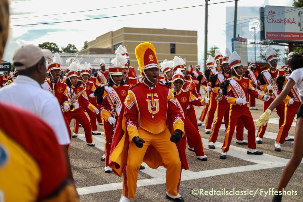 Texas Southern University marching band performing in red-and-gold uniforms during a street parade