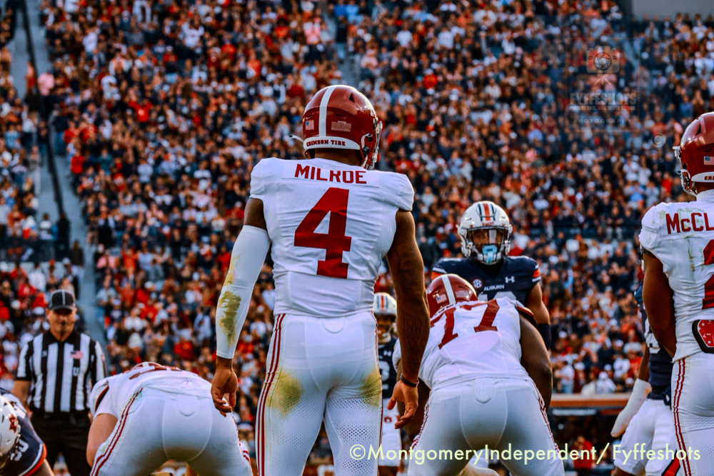 Alabama Crimson Tide football players line up against Auburn during a crowded college football game