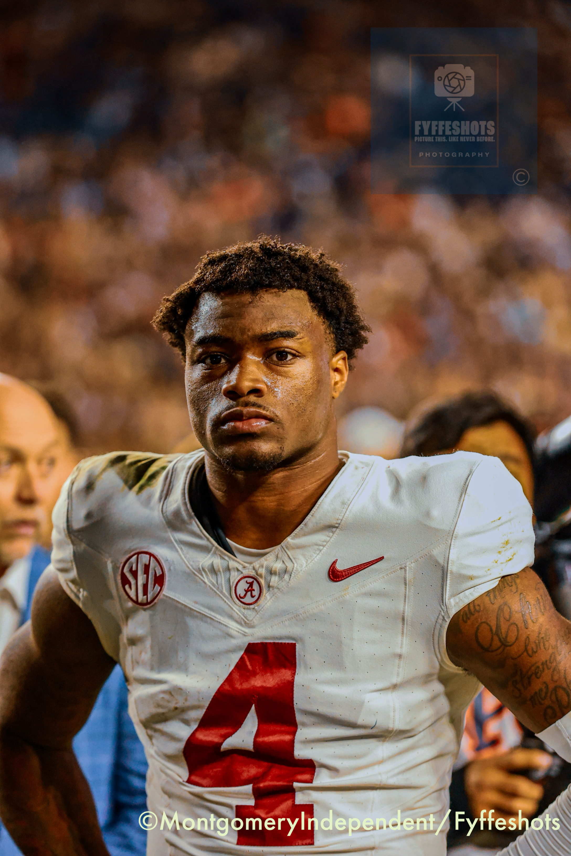 Alabama Crimson Tide football player in a white No. 4 jersey standing on the field during a game