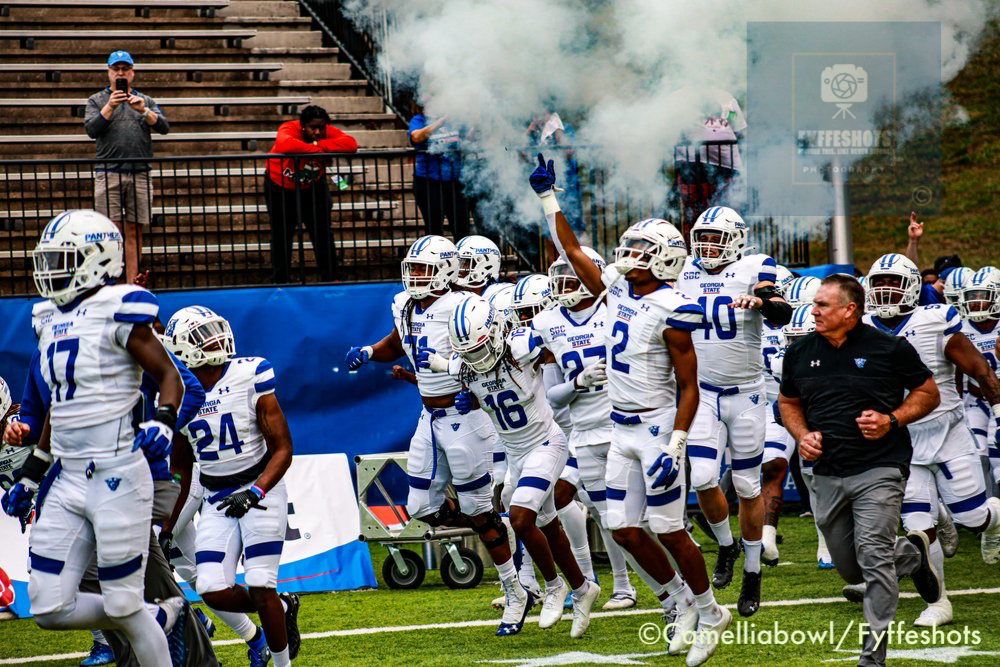Georgia State Panthers football players run onto the field through smoke before a game