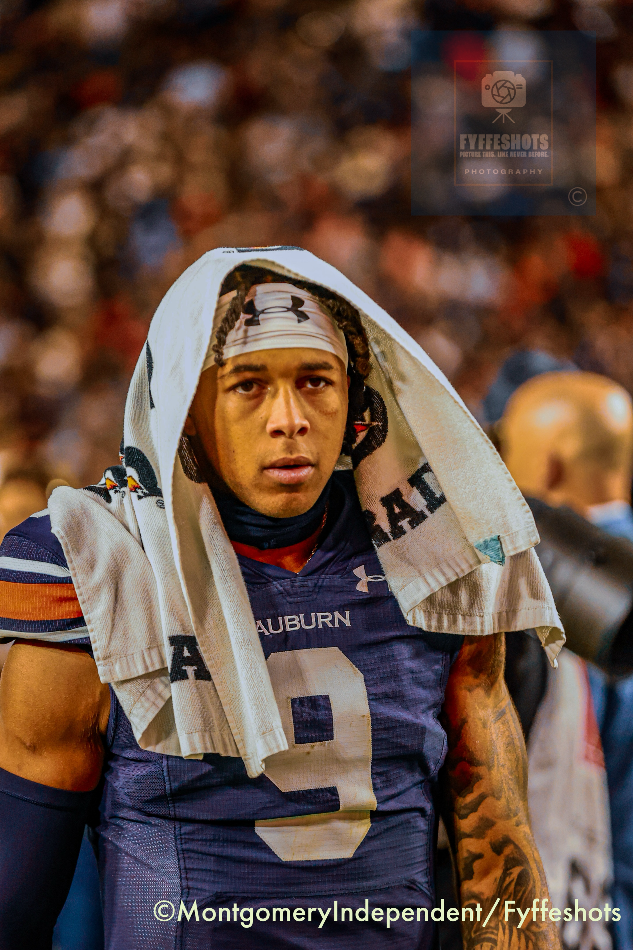 Auburn football player wearing jersey number 4 and a white towel over his head during a game.