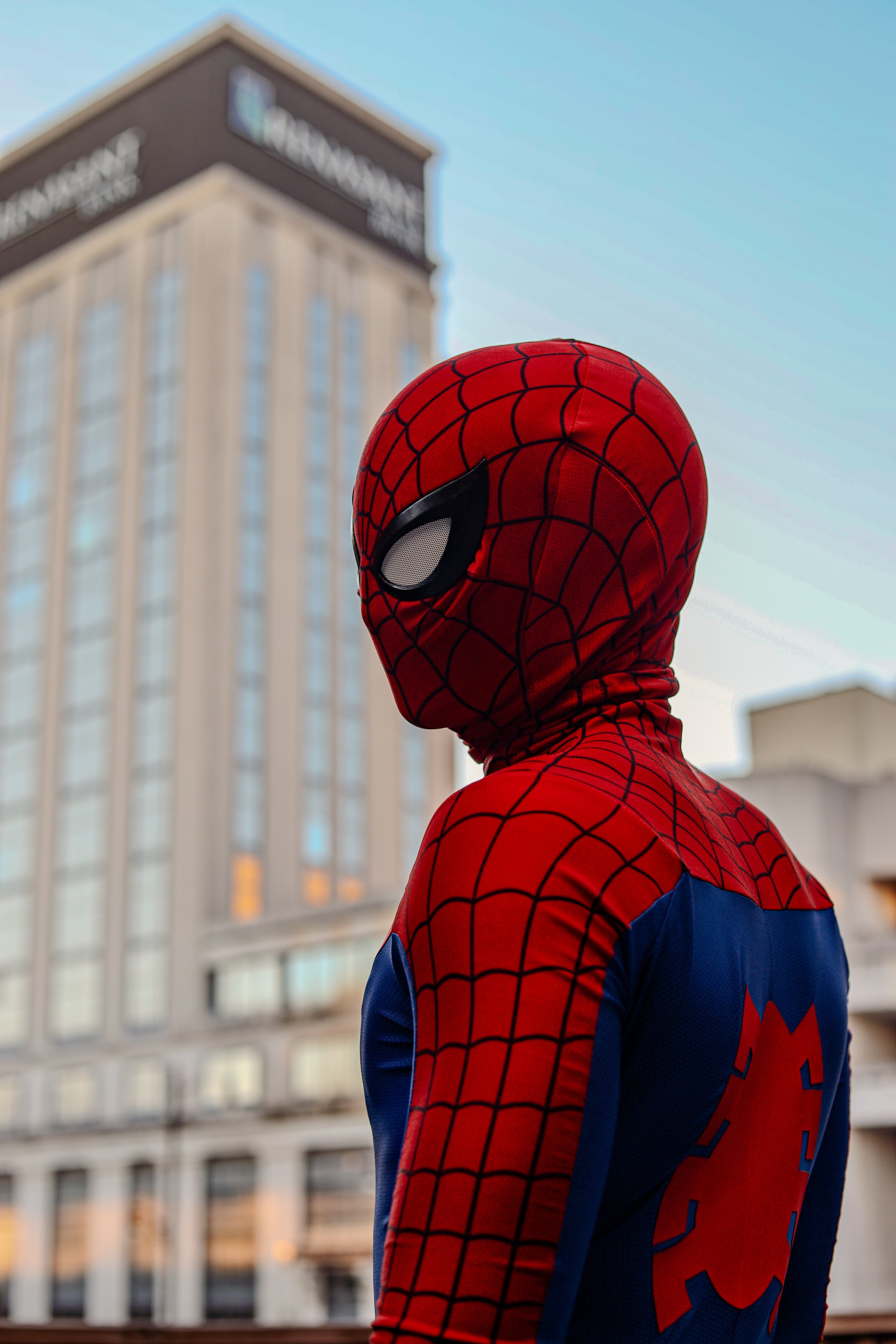 Person wearing a red and blue Spider-Man costume and mask indoors
