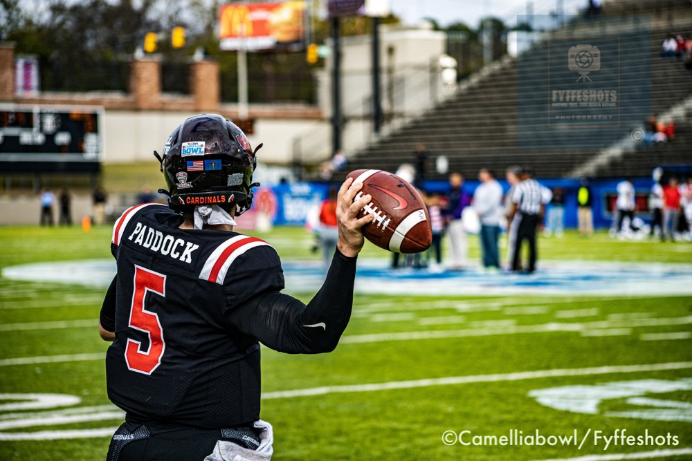University of Louisville Cardinals quarterback P. Paddock, wearing number 5, holds a football on the field during the Camellia Bowl.