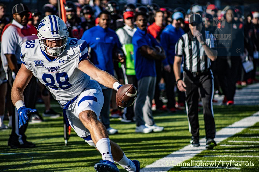 Georgia State football player wearing number 88 runs with the ball along the sideline.