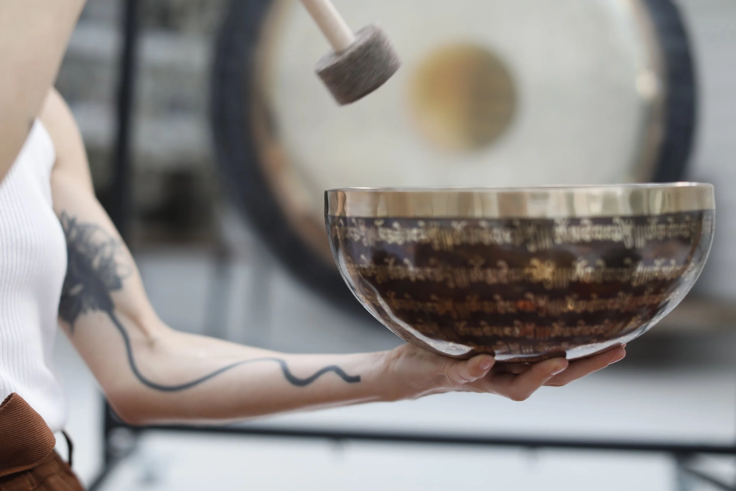 Une personne tenant un bol en céramique en verre, avec un pilon, dans une ambiance de cuisine ou de pâtisserie.