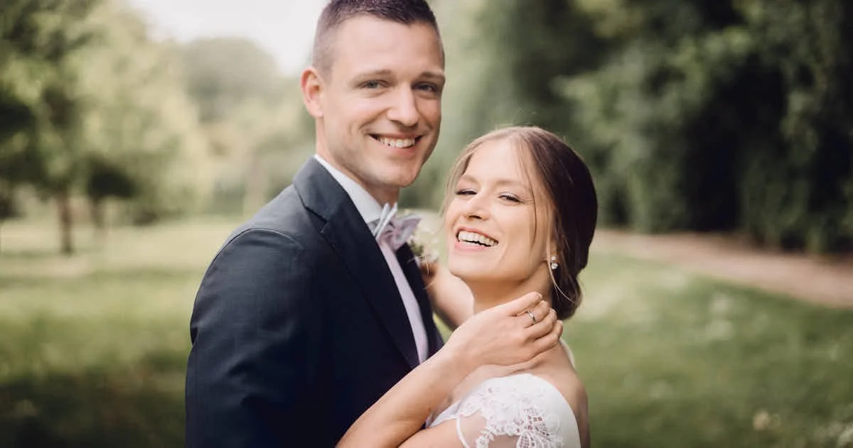 Ein glücklich strahlendes Hochzeitspaar berührt sich