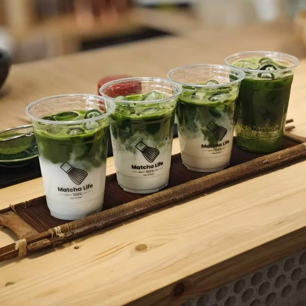 Row of iced matcha drinks prepared by Matcha Life on a wooden counter.