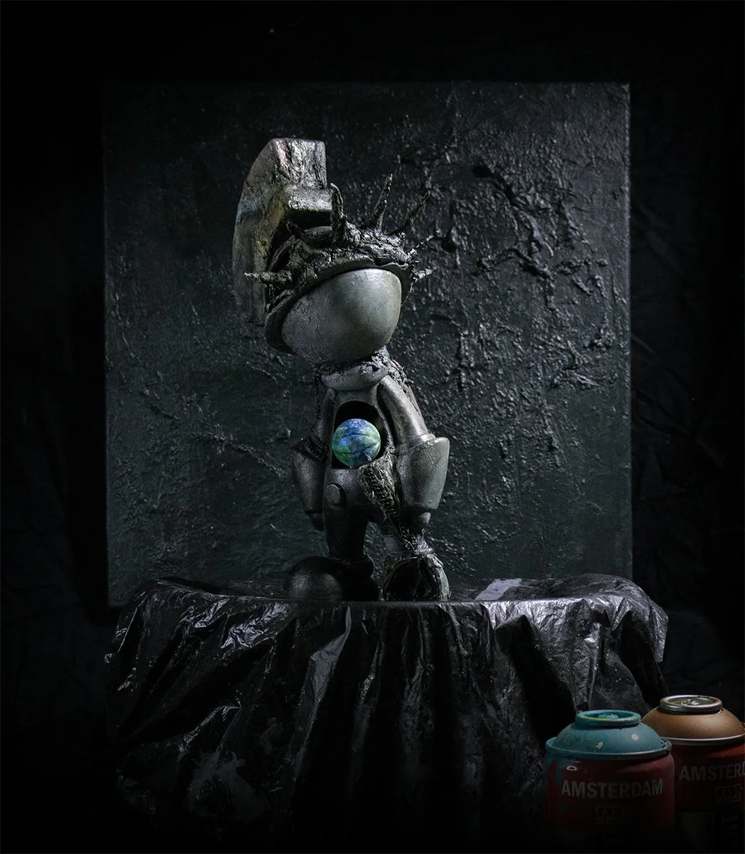 Liberty Lamenting the World art toy front view by Atom Toys Studios, featuring cracked helmet and Earth core