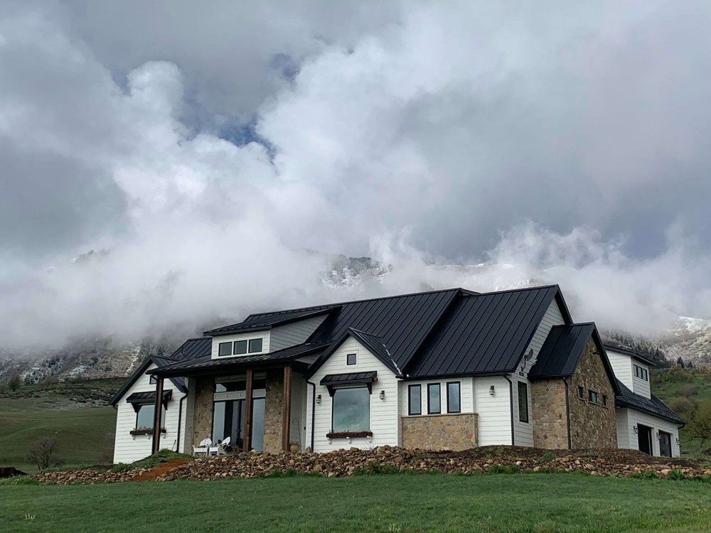 Custom home with stone and white siding on a hillside in Cache Valley, Utah