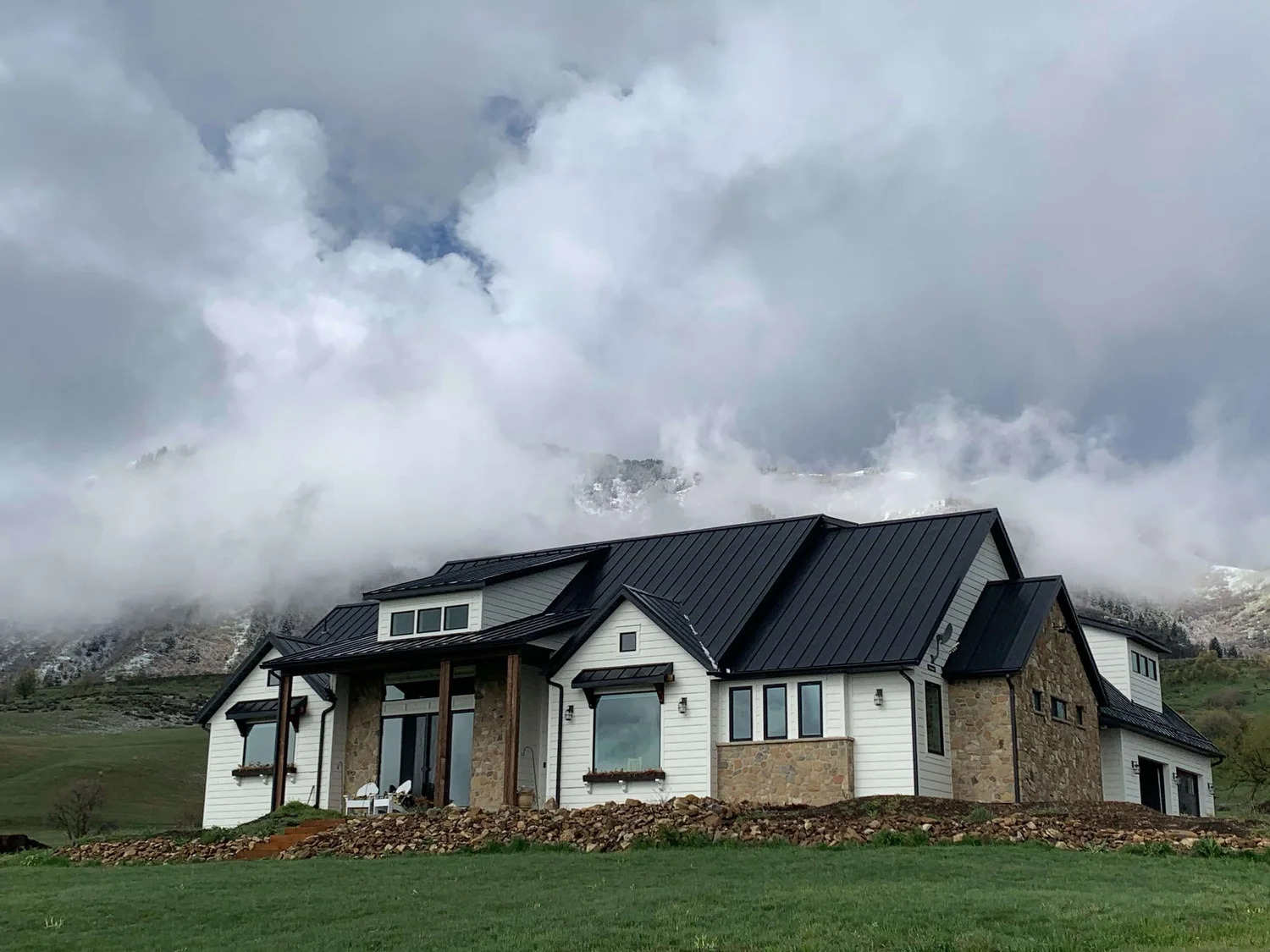 Custom home built by Bergeson Construction on a bench lot in Cache Valley, Utah, with snow on the range behind it