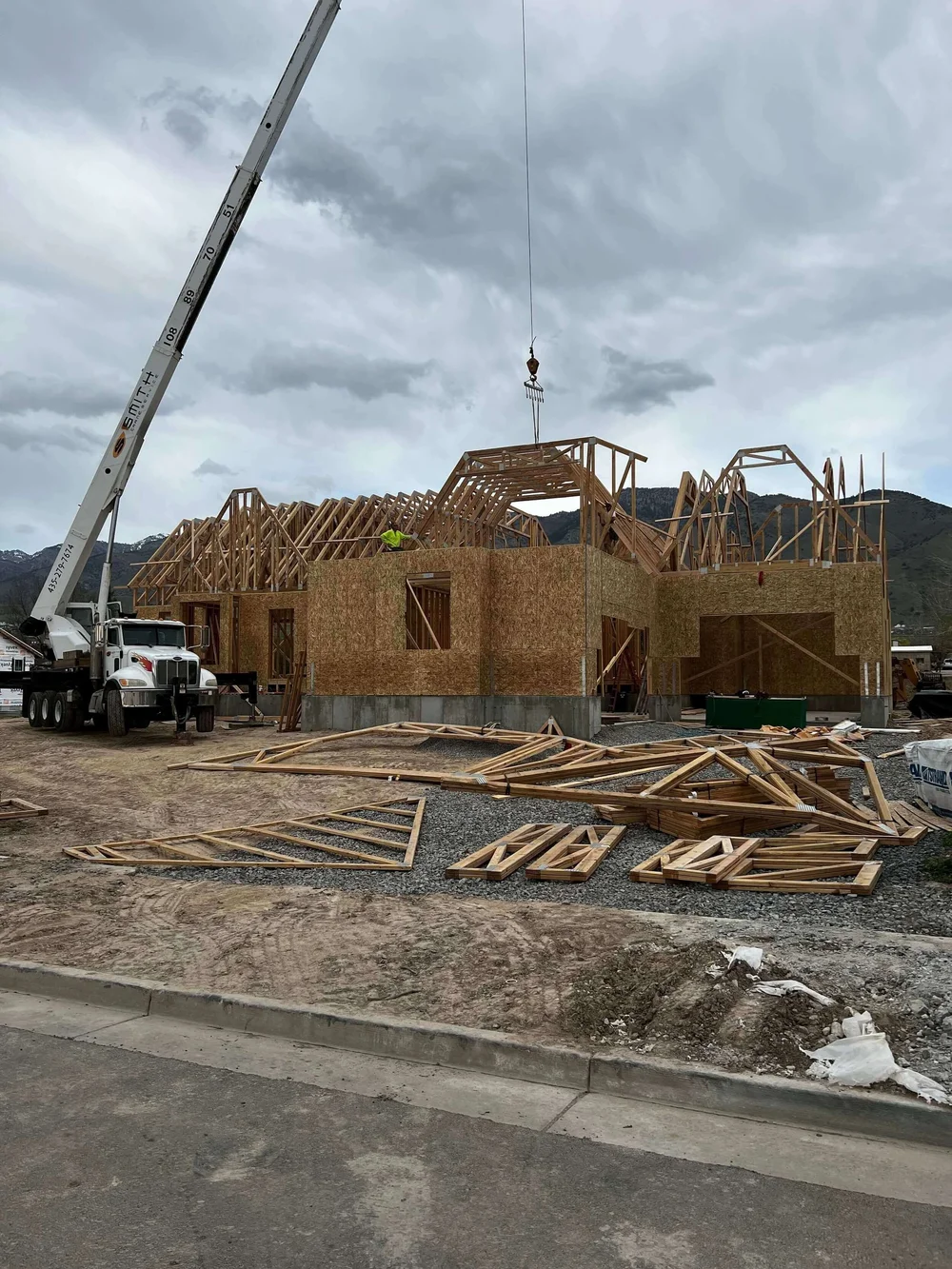 Crane setting roof trusses on a Bergeson Construction project in Cache Valley, Utah