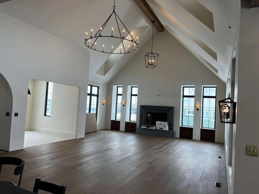Living room with a vaulted ceiling, hardwood floors and a modern chandelier in a Bergeson custom home