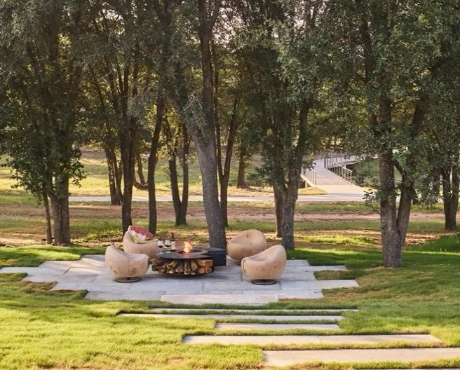 A destination within the landscape.

Beyond the house, a path leads through the lawn to a quiet gathering place beneath the existing trees. We kept this part of the landscape intentionally simple&mdash;limestone underfoot, the tree canopy overhead, a
