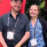 Dan and Christine Cooney posing in front of red BCB letters