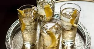 Highball glasses with citrus twists on a silver tray