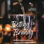 Brown spirits being poured from a bottle into a rocks glass