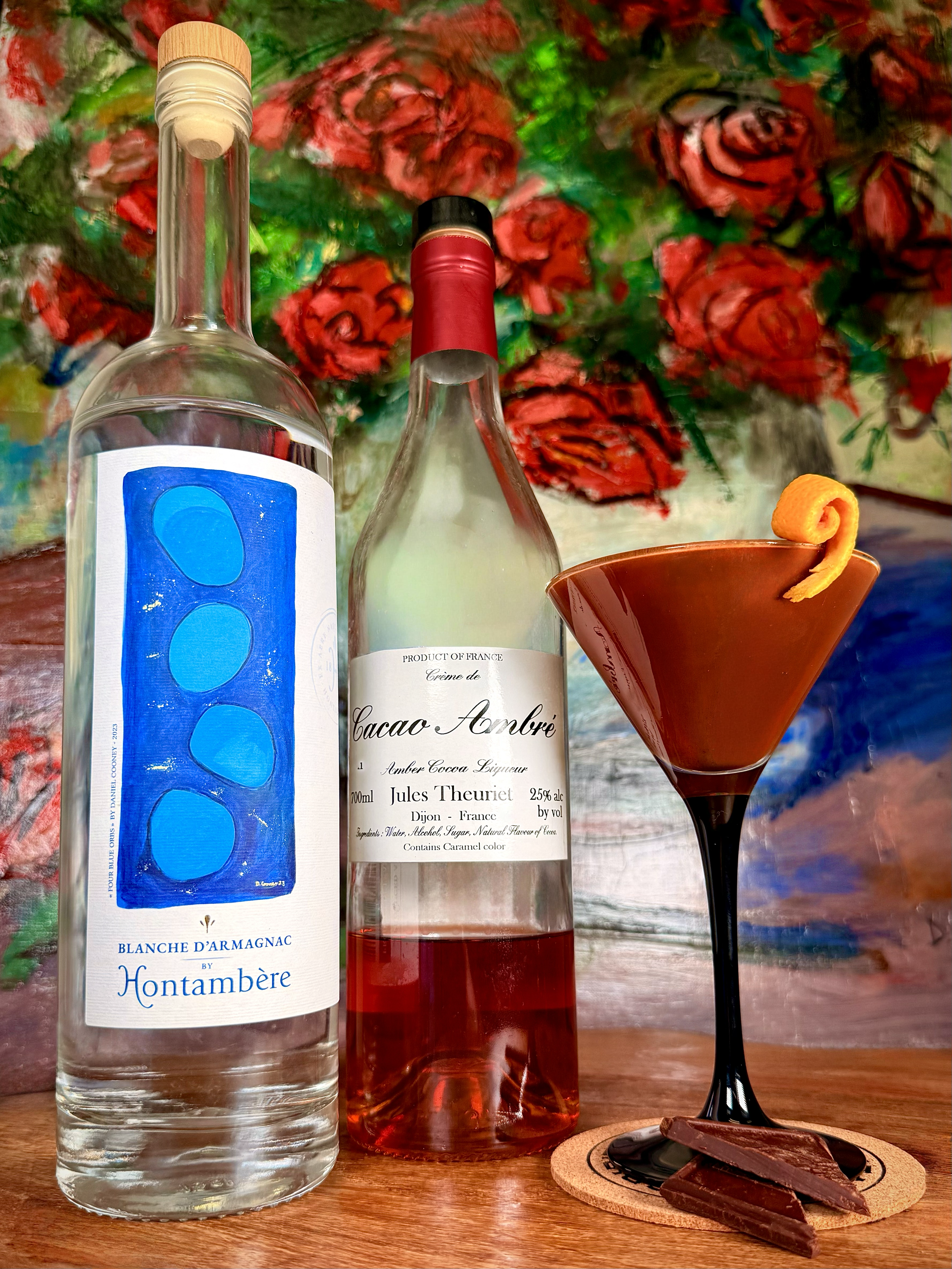 Rich chocolate martini cocktail garnished with an orange twist. Crafted with Hontambère Blanche d'Armagnac and Jules Theuriet Crème de Cacao Ambré bottles. Elegant French dessert cocktail recipe.