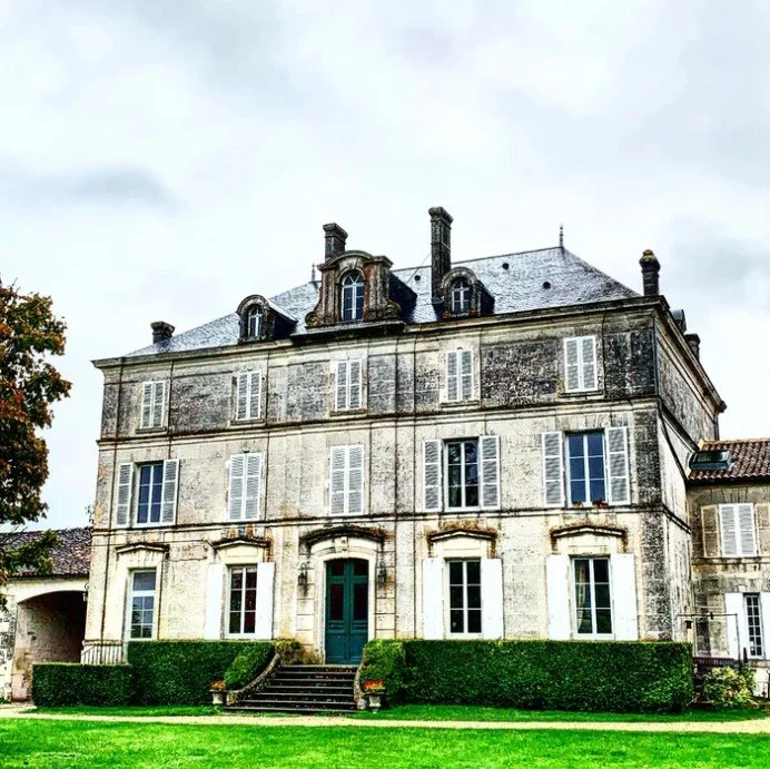 Image of a French Chateau against a cloudy sky, known as La Pouyade, the home of Cognac Jean Fillioux in the Grande Champagne region. 