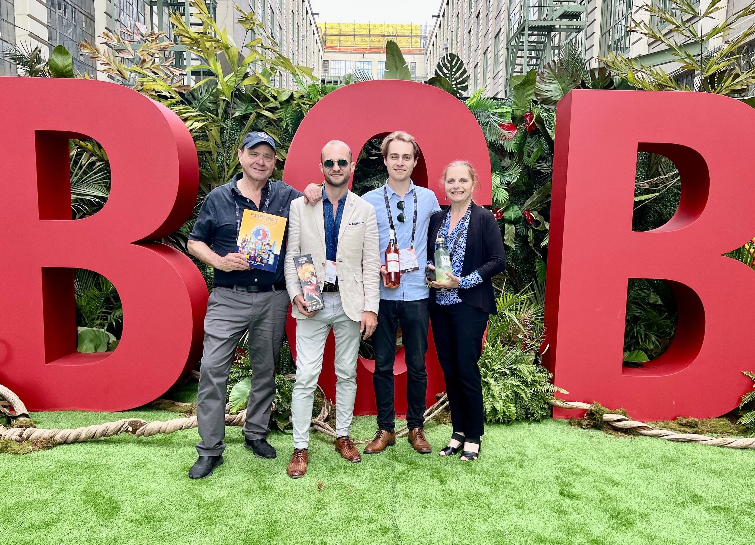 The Cooney family (father, two sons, and mother) in front of giant red letters BCB