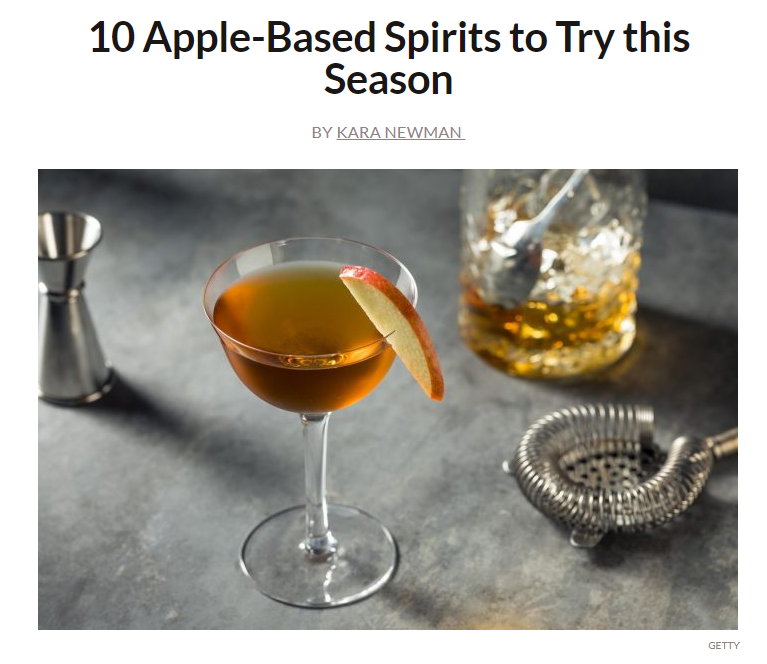 Picture of a brown cocktail in a coupe glass with apple slice garnish