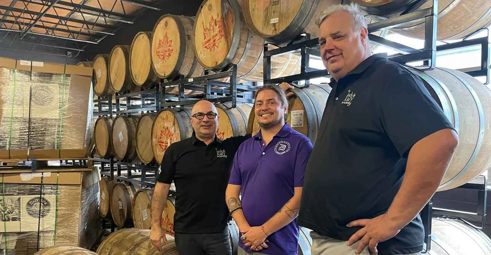 Ryan and Randall from Julio's liquors visiting Macaulay Minton in the rickhouse at Dark Arts Whiskey