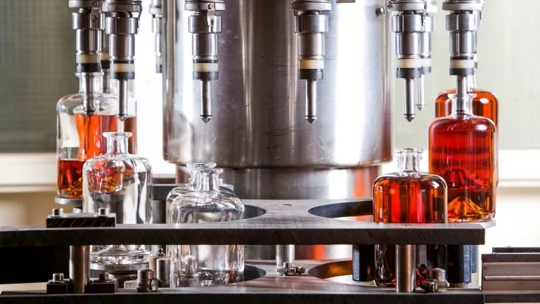 Bottles on a bottling line being filled with spirits