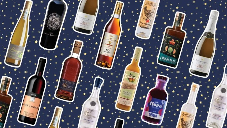 Right-leaning bottles of wine, spirits, and non-alcoholic drinks on a dark blue background speckled with gold stars.