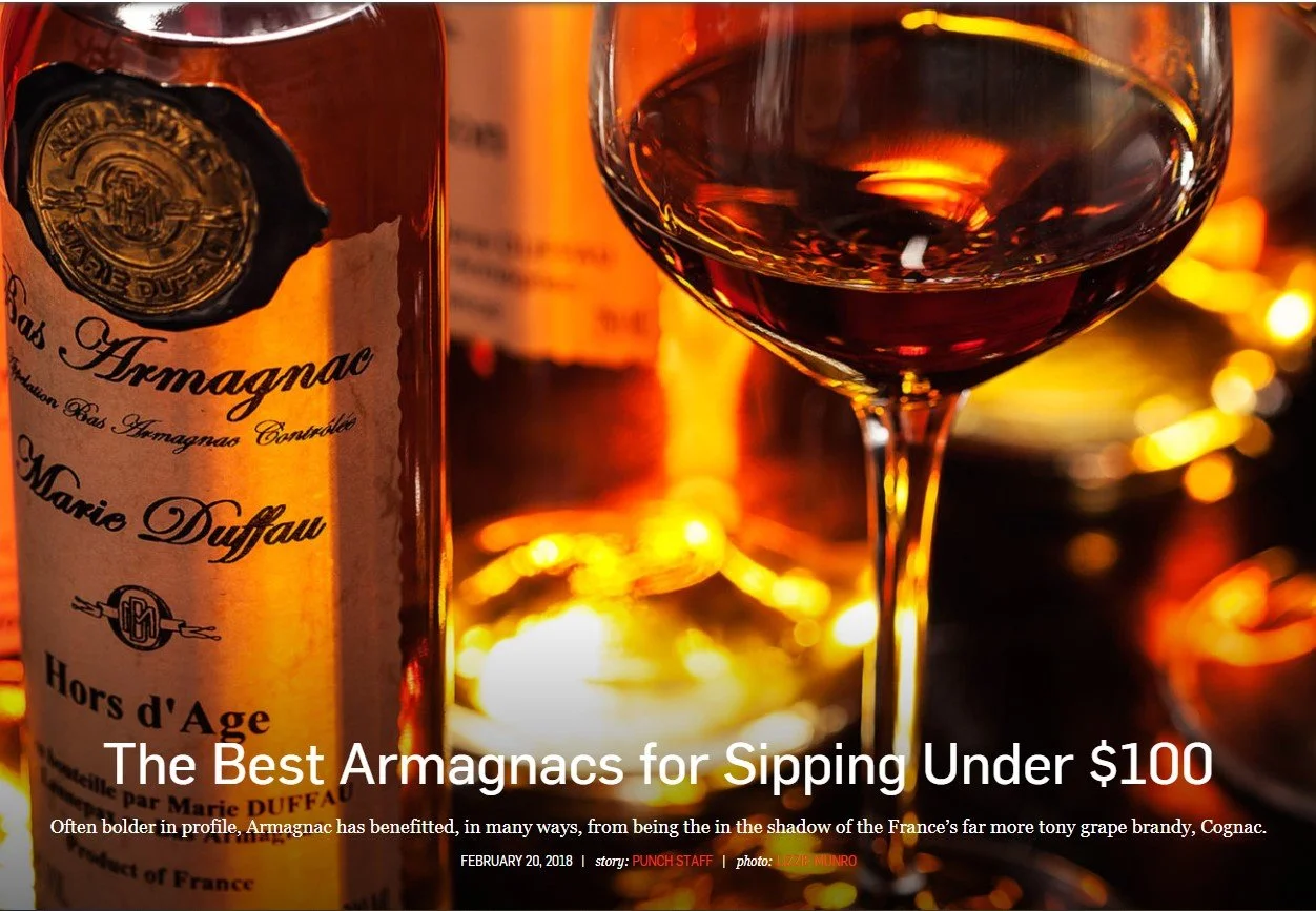 Dramatically lit bottle of Marie Duffau Armagnac with tulip glass of brandy