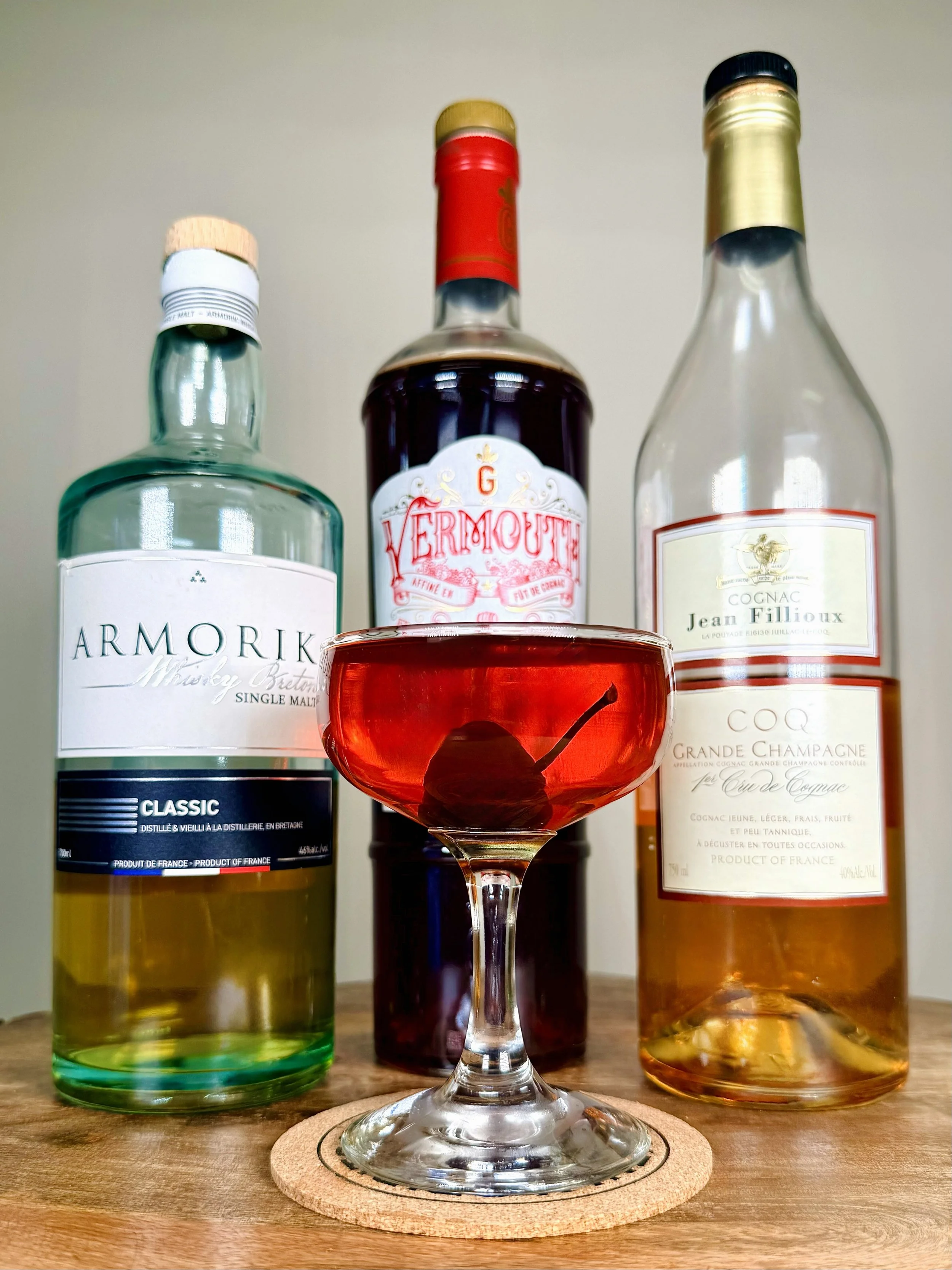 Vieux Carré cocktail with a cherry garnish. Features Armorik Single Malt Whiskey, Guerin Vermouth, and Jean Fillioux Cognac. A premium French spirit twist on a classic cocktail.