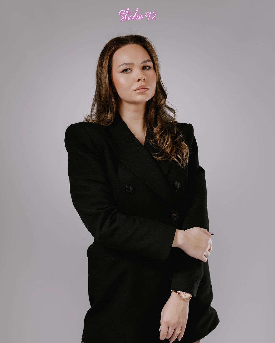 Woman taking a selfie with a smartphone, wearing a black shirt.