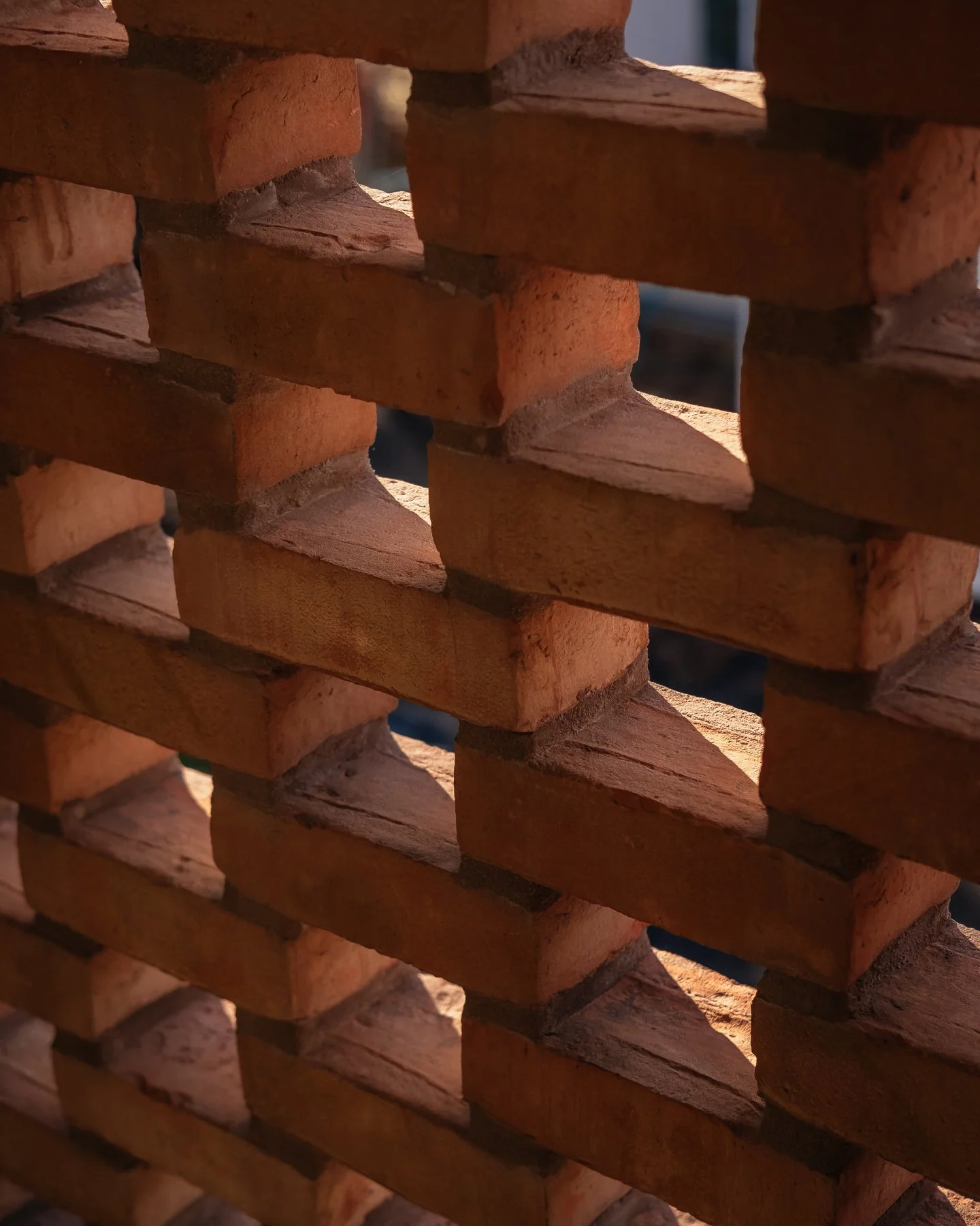 Close-up view of stacked red bricks creating a wall, with some mortar visible.