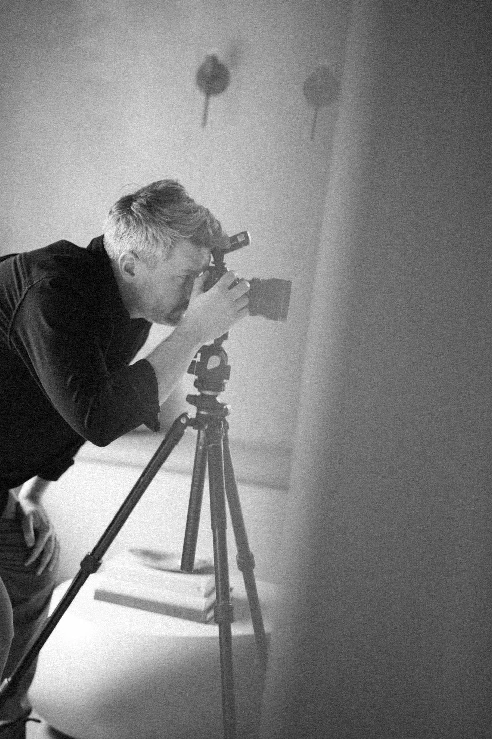 Branding image of Jeff Jones holding a camera for a shoot in greyscale