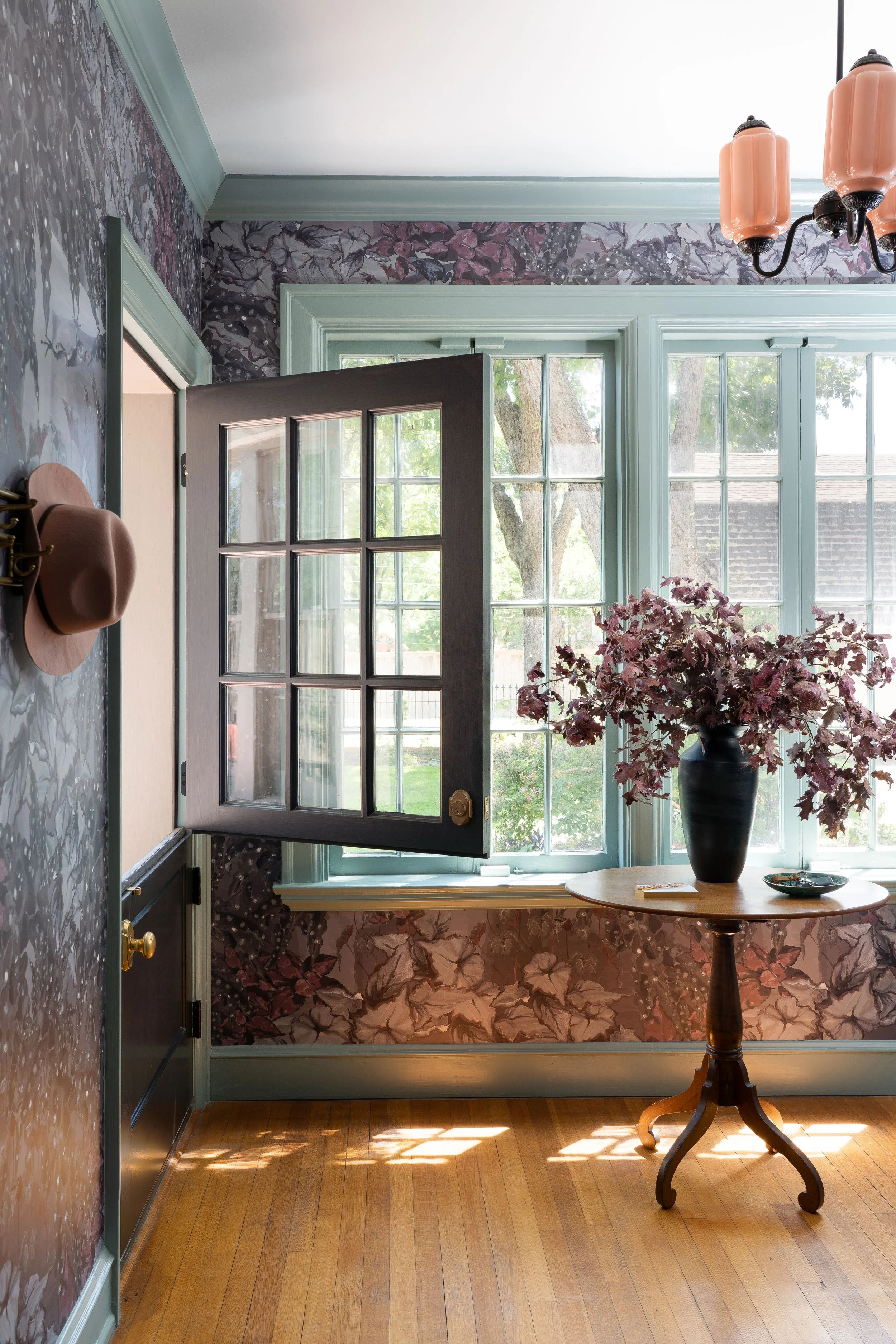 Interior design photography by Jeff Jones featuring a wallpapered vestibule with Dutch door, wood floors, teal trim, and vintage chandelier. Perfect example of interior design photographer’s work in Austin, Texas.