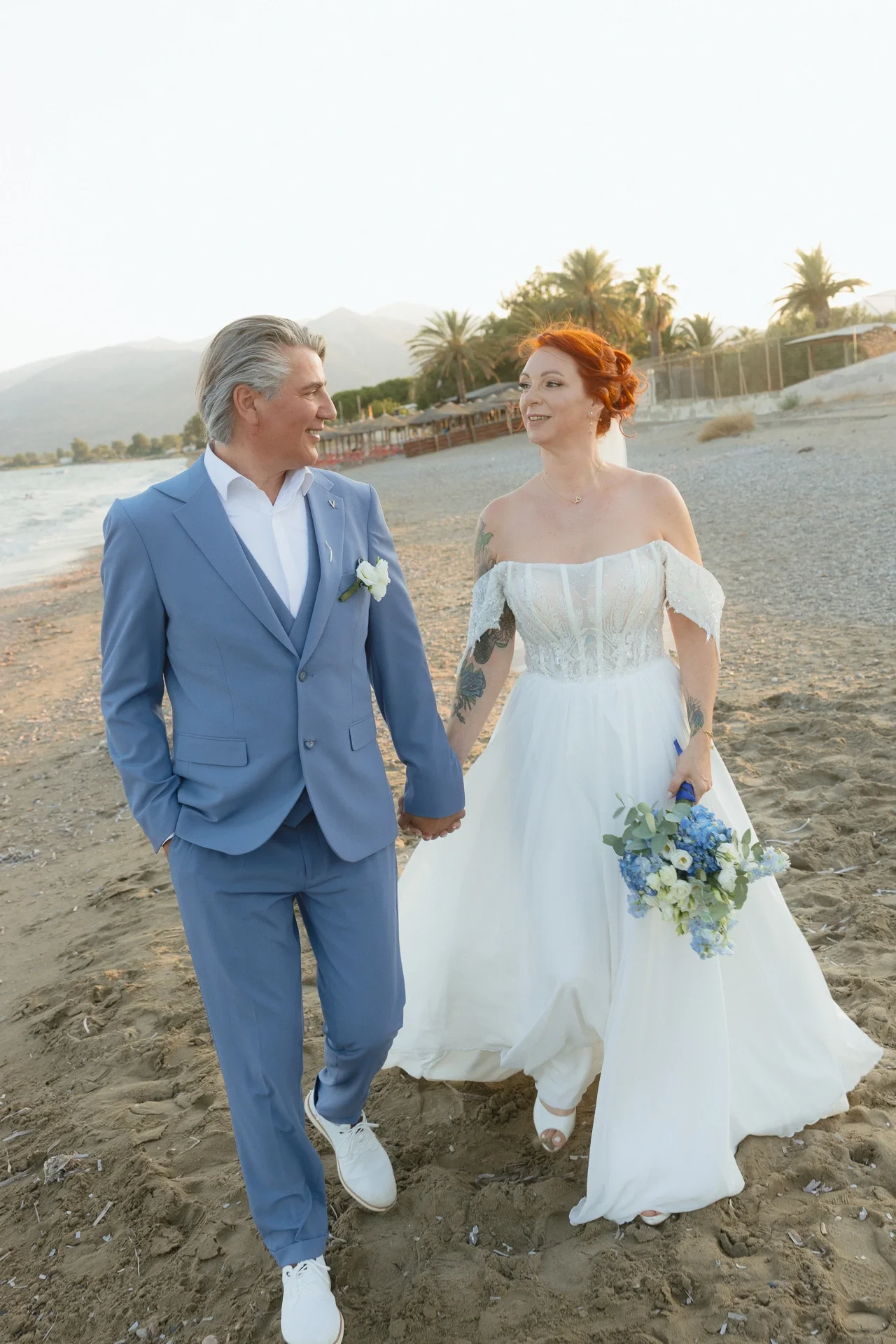 groom-and-bride-walking-on-the-athenian-riviera.webp