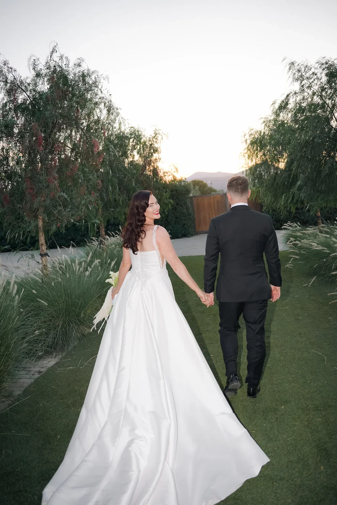 bride and groom waving at the guests